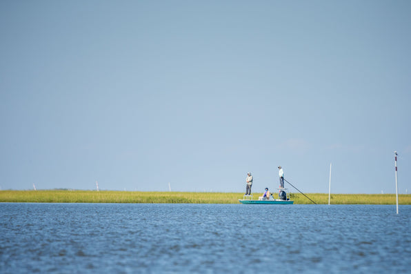 Fly fishers fish from a flats boat on Louisiana marsh waters