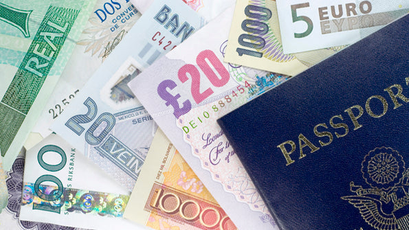 United States passport lying on assorted international banknotes including euros and British pounds, suggesting international travel