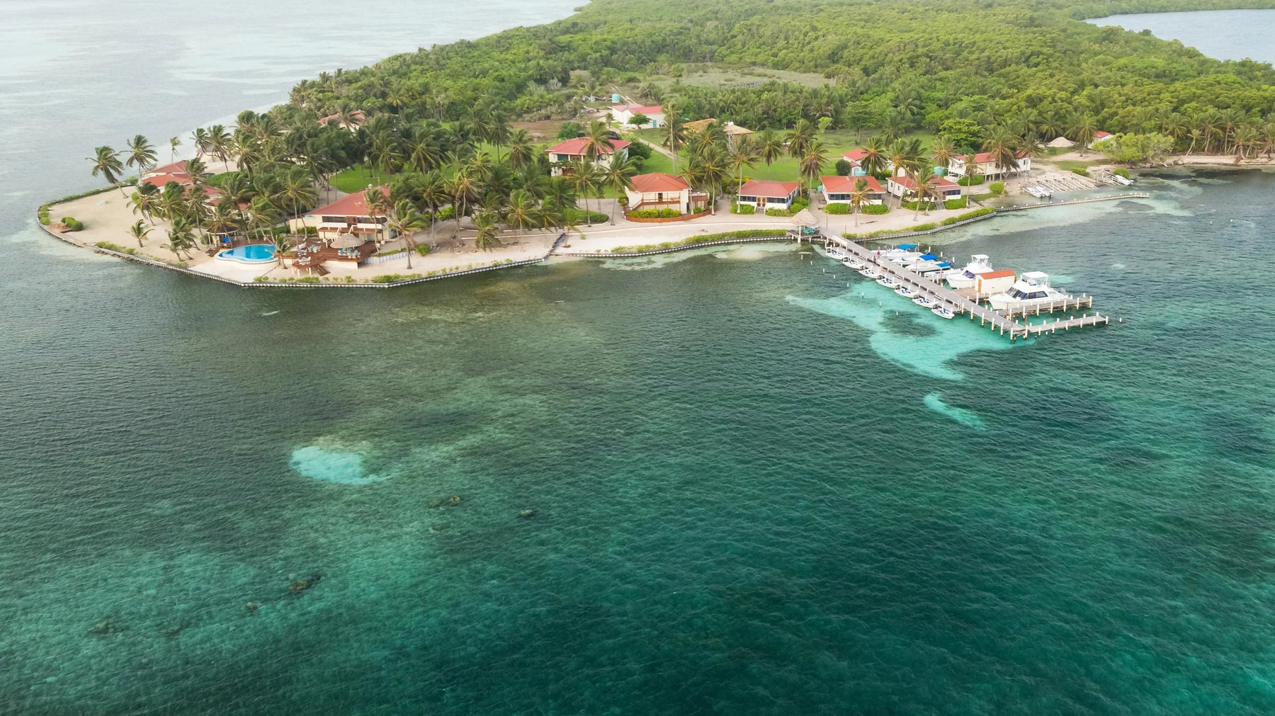 Aerial view of Turneffe Flats Lodge on a tropical island surrounded by turquoise Caribbean waters