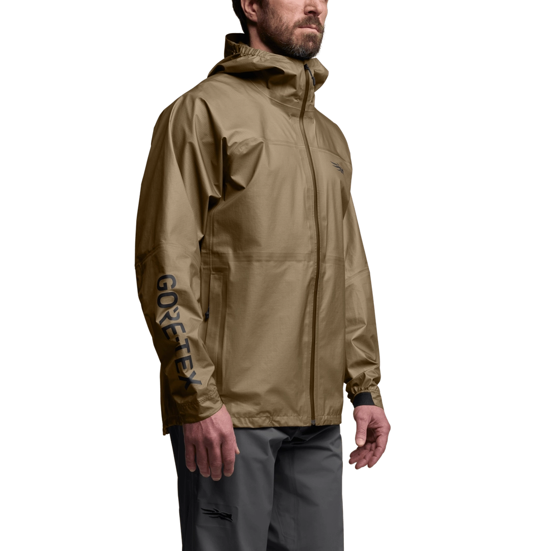 Three-quarter view of SITKA Dew Point UL jacket in brown with hood, waterproof zip and GORE-TEX logo on sleeve on model