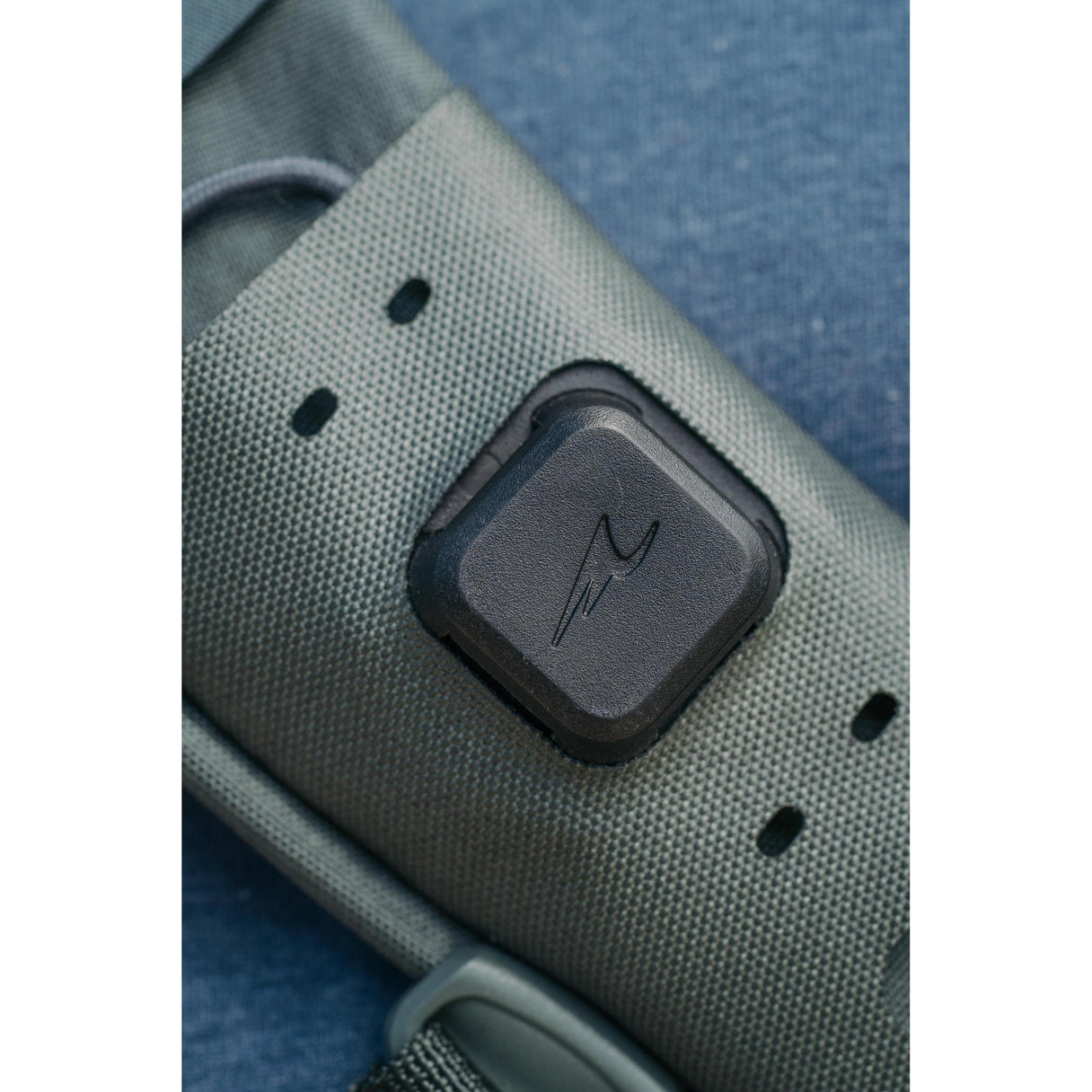 Close-up of Umpqua LINK Base Station showcasing square puck attachment on textured olive-green strap